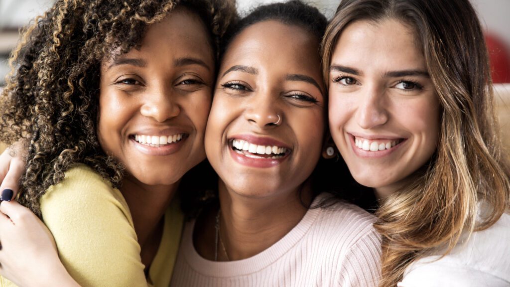 Three women from diverse backgrounds enjoying healthy skin